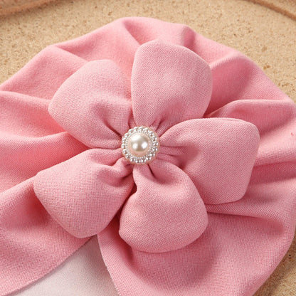 Infant turban hat with subtle pearl accents, combining comfort and elegance for newborns.