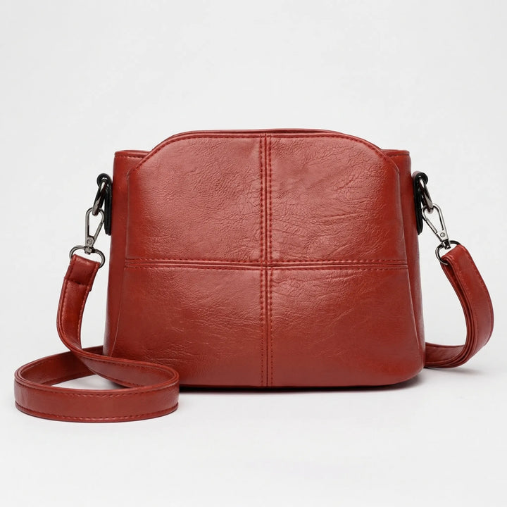 Versatile small black women's crossbody bag featuring a stylish stitched panel design, perfect for any outfit.