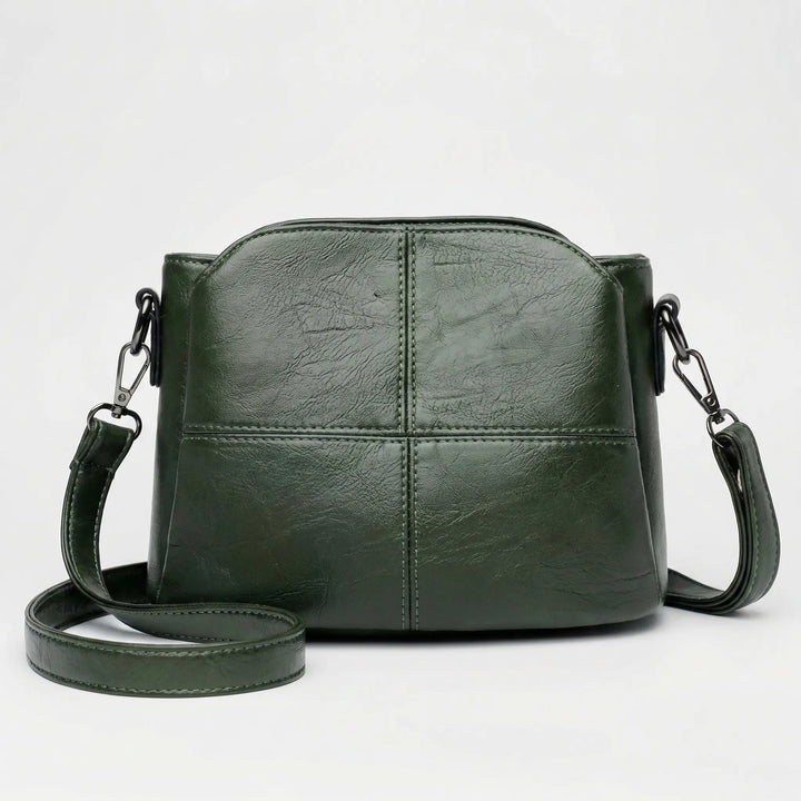 Stylish women's handbag: a versatile small crossbody shoulder bag in black, red, or green with stitched panels.