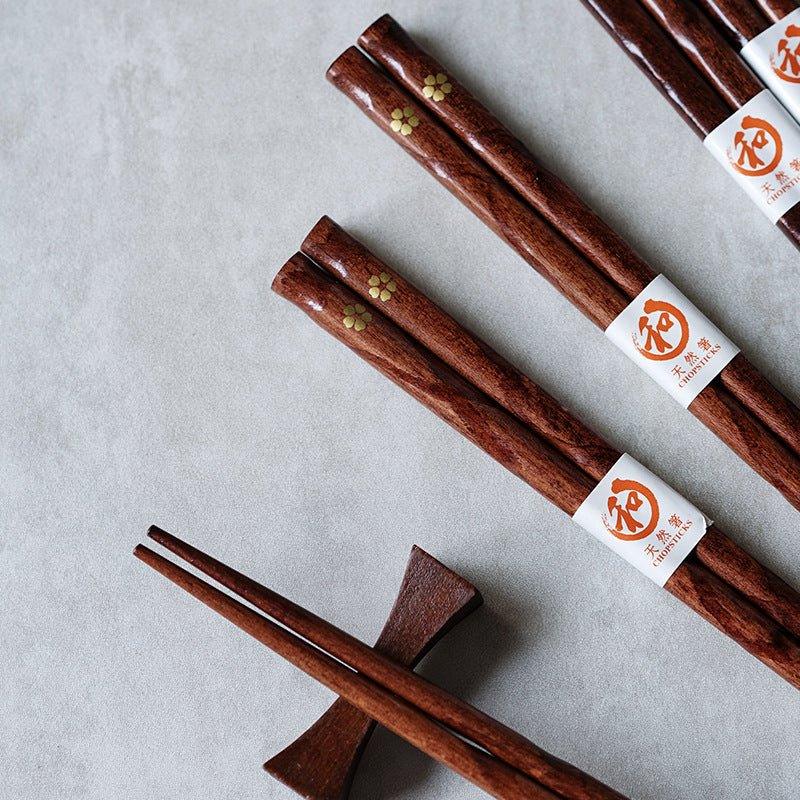 Close-up of a golden cherry blossom wooden chopstick, showcasing elegant Japanese tableware and fine detail.