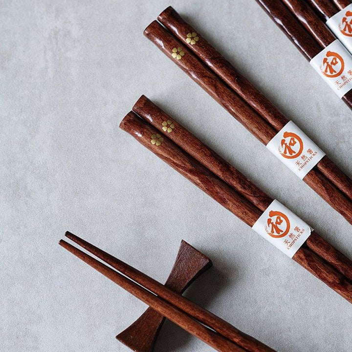 Close-up of a golden cherry blossom wooden chopstick, showcasing elegant Japanese tableware and fine detail.