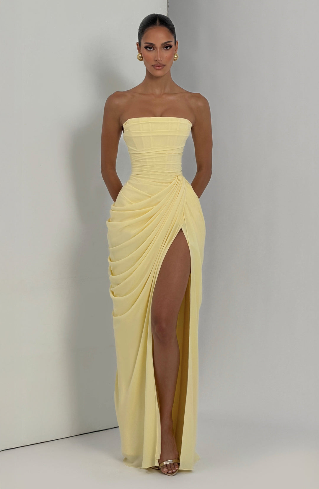 Elegant women's strapless party dress, sculpted corset bodice, and stylish column skirt with a slit.