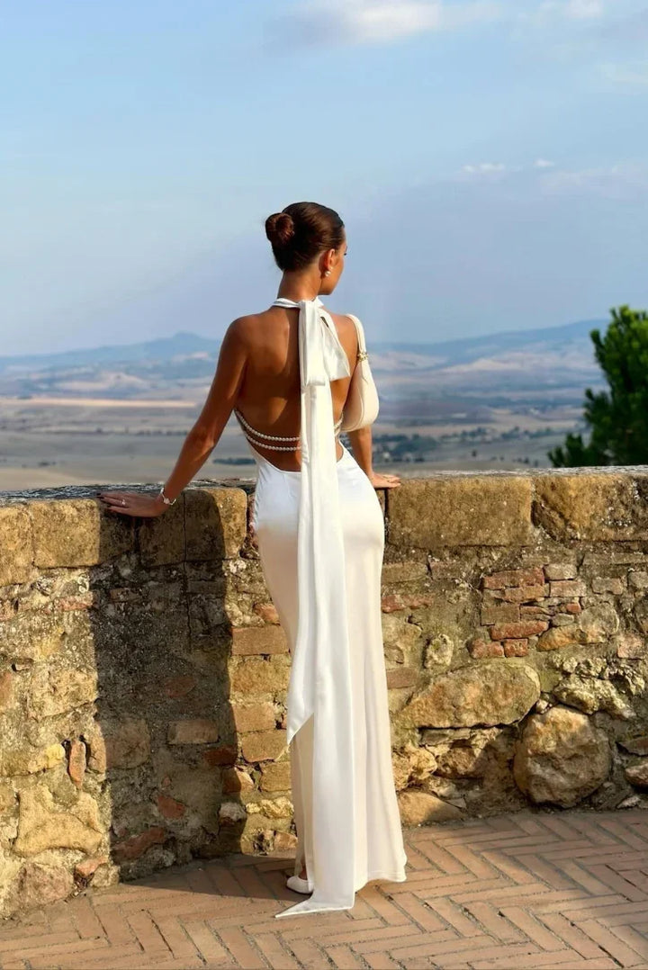 Stunning white maxi dress with halter neckline and backless cut. Elegant formal wear or chic party dress for women.