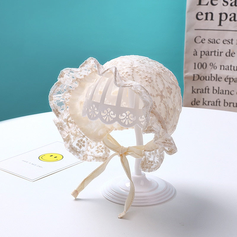 Close-up of a crocheted lace baby bonnet hat with a pretty flower detail for infants.