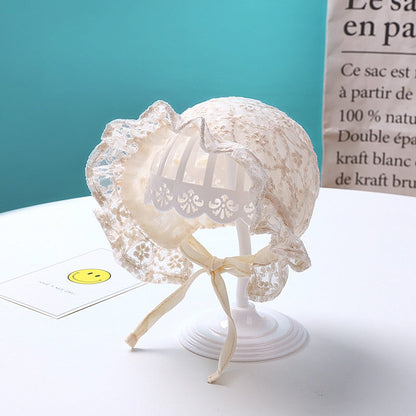 Close-up of a crocheted lace baby bonnet hat with a pretty flower detail for infants.