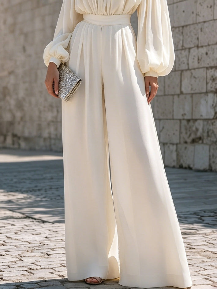 White off-shoulder flowing maxi dress with bishop sleeves, elegant for any festive occasion.
