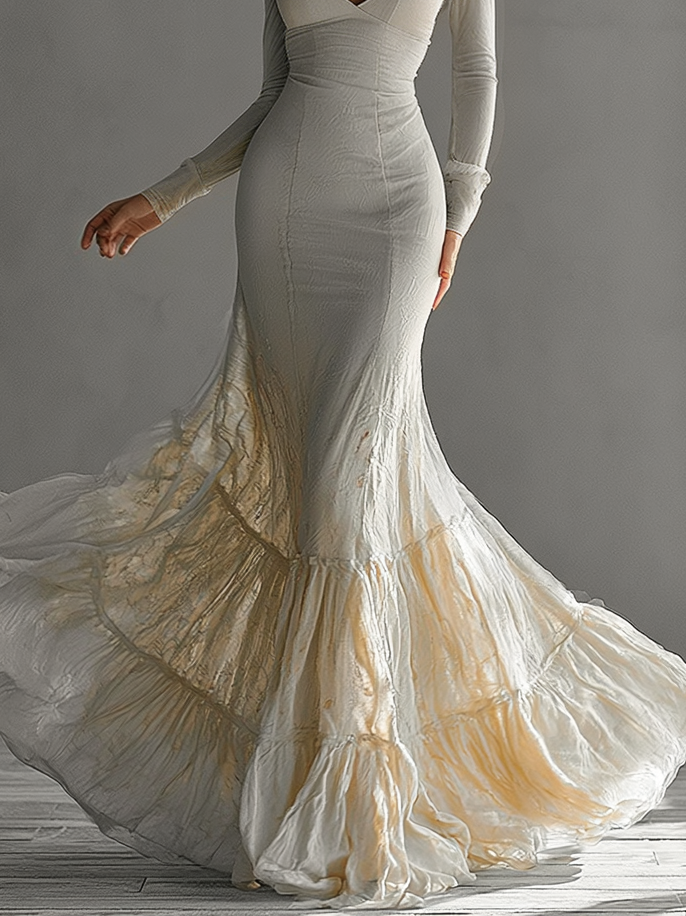 Sophisticated beige mermaid maxi dress with deep V-neck and ruffled hem, ideal as an evening gown or for special occasions.