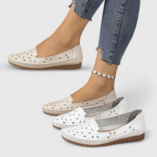 Elegant women's beige slip-on ballet flats with perforated floral design, scalloped edge, and comfortable round toe.