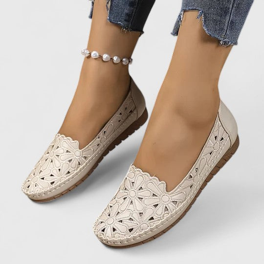 Women's comfortable white ballet shoes with delicate floral cutouts and an elegant slip-on everyday design.