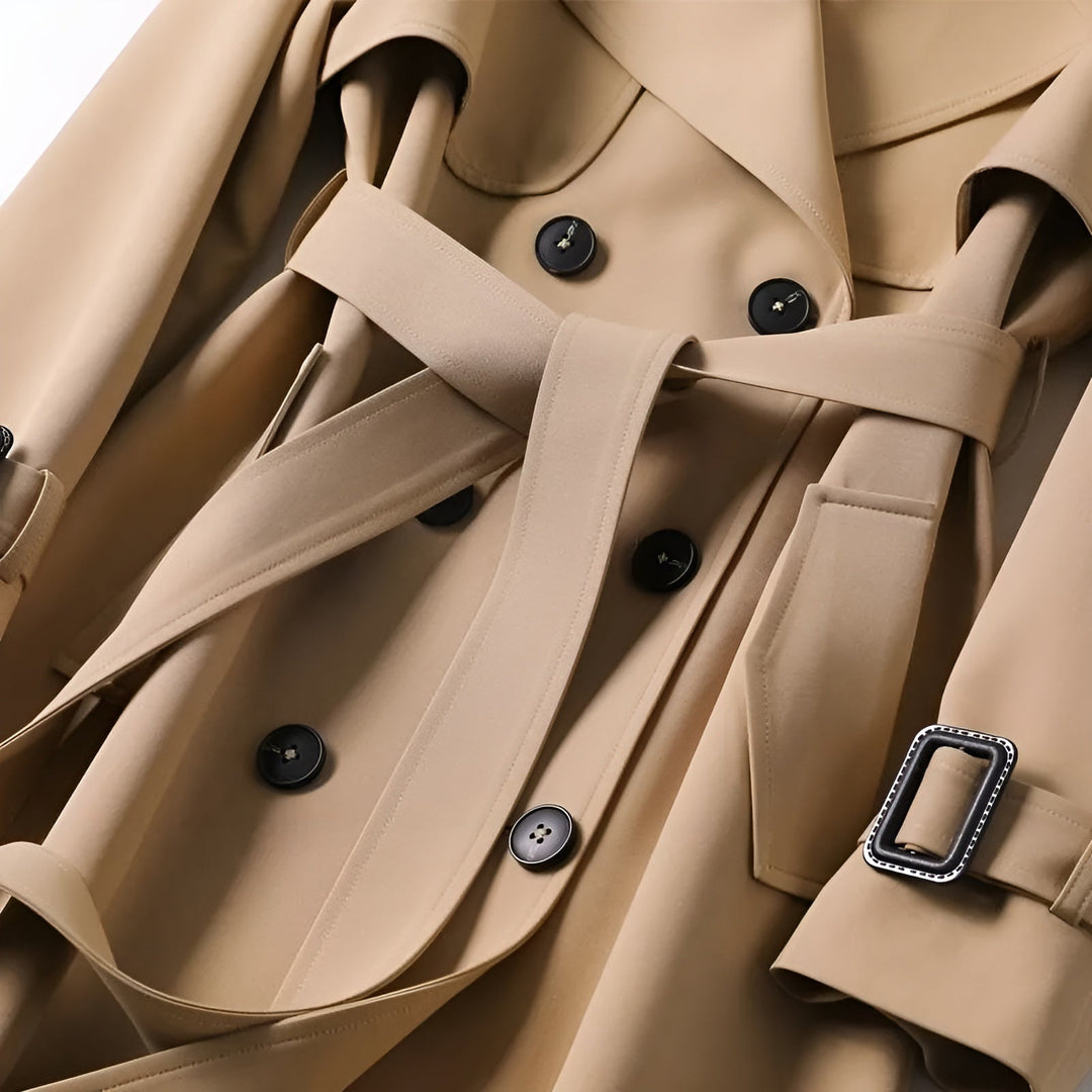 Close-up of the double-breasted buttons & belt on a sophisticated women's water-resistant trench coat.