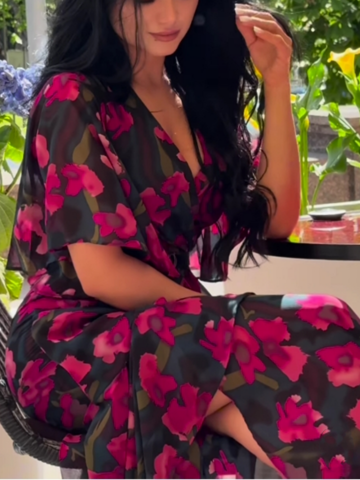Flowy black floral print maxi dress for women, featuring a V-neck and elegant trumpet sleeves. Ideal for parties or casual chic.