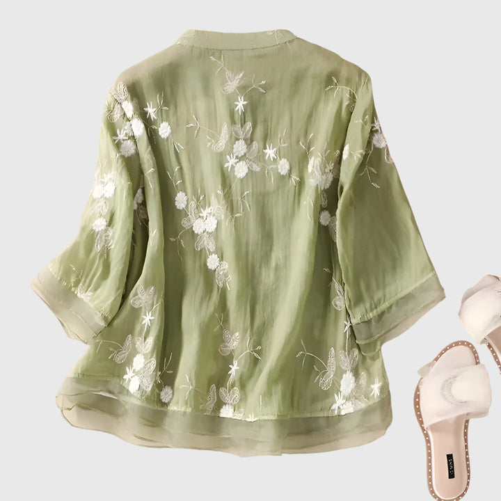 Delicate floral embroidery on a women's elegant blouse, ideal for both casual wear & special occasion styling.