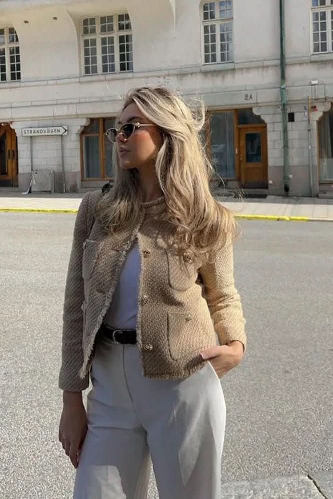 Close-up of a stylish women's cropped blazer, highlighting the elegant button closure & tailored fabric.