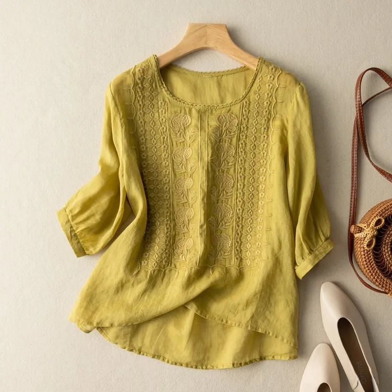 Stylish women's embroidered puff sleeve blouse, round neck, high-low hem, ideal for elegant spring fashion.