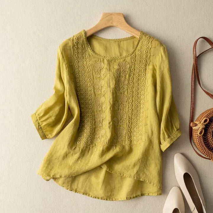 Stylish women's embroidered puff sleeve blouse, round neck, high-low hem, ideal for elegant spring fashion.