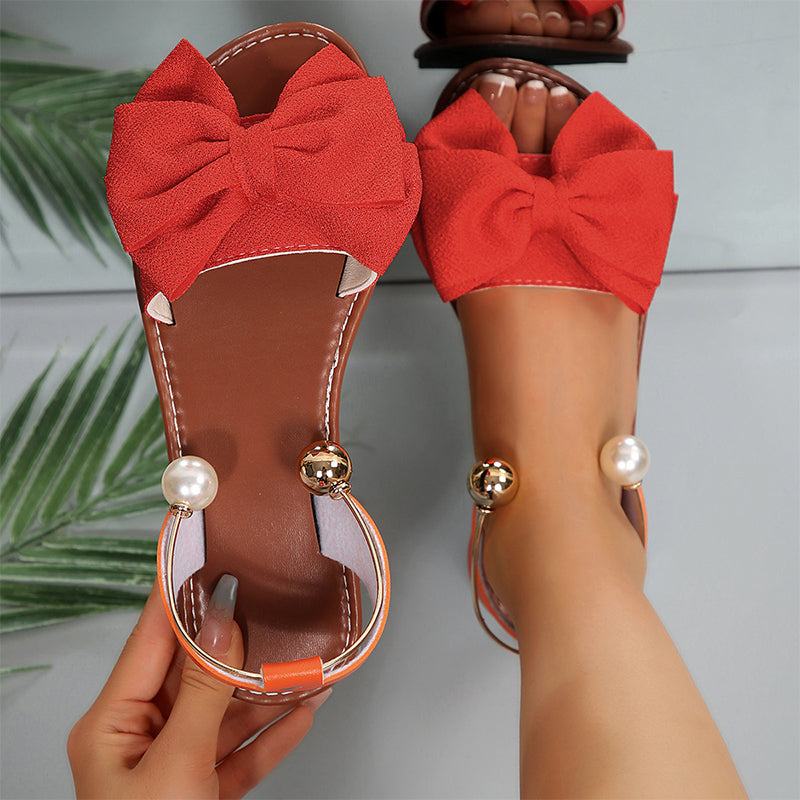 Stylish women's flat sandals with elegant bow & beads, ideal for vacation and casual summer fashion.