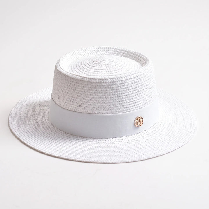 Chic women's wide brim sun hat with a flat top, ideal for stylish beach outfits and summer travel.