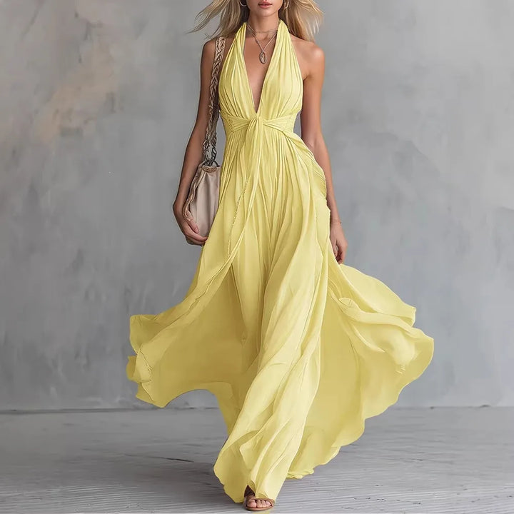 Chic women's backless halter maxi dress with pleated details & side slit; an elegant evening gown for special occasions.