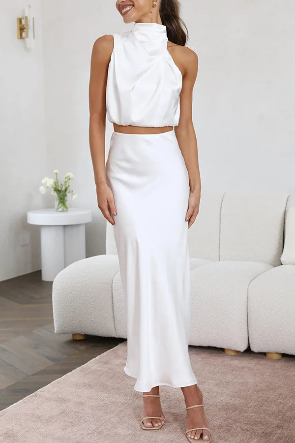 Draped women's elegant evening wear set: halter crop top and a graceful flowing maxi skirt.