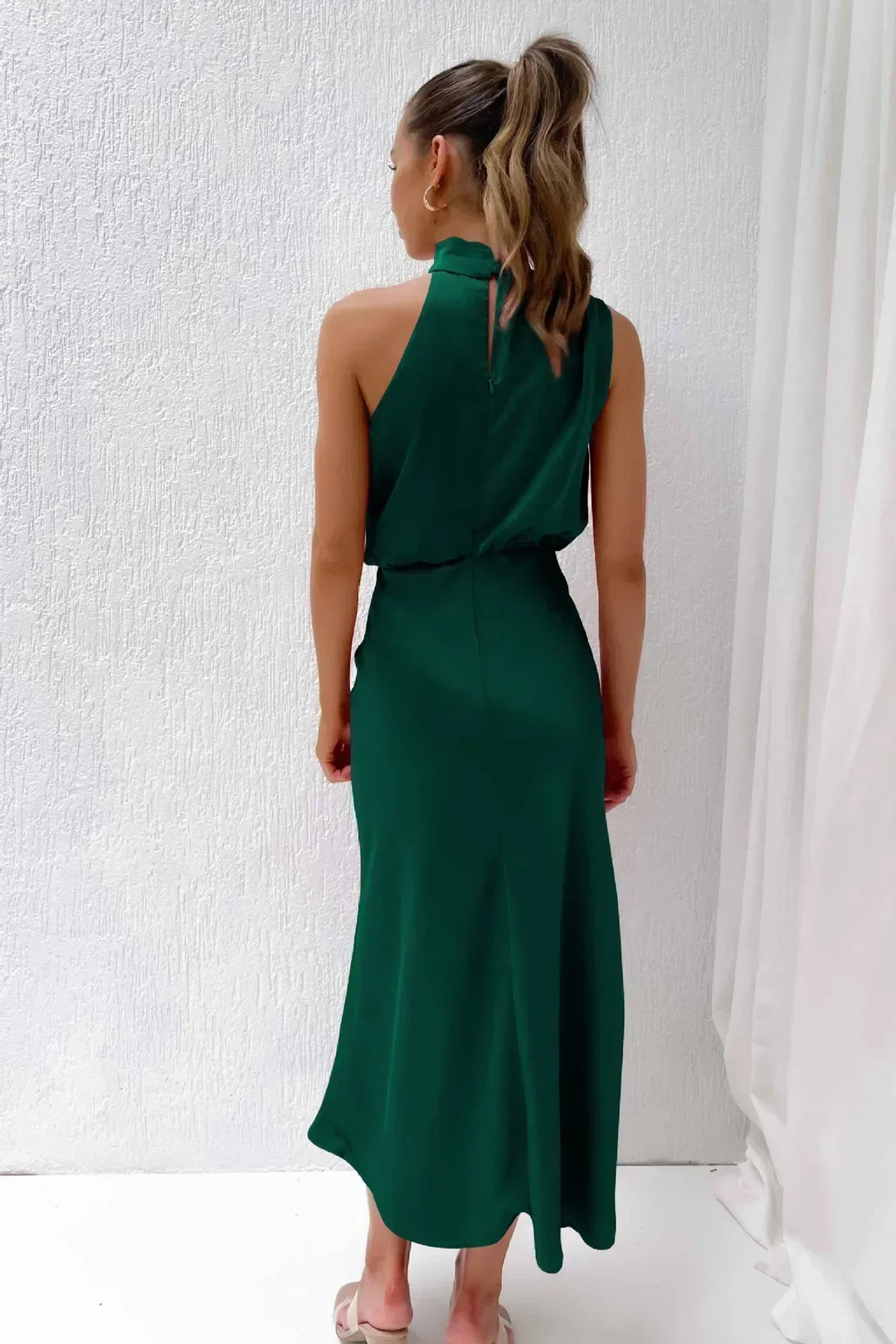 Glamorous women's party dress: a floor-length halter evening gown with an open back.
