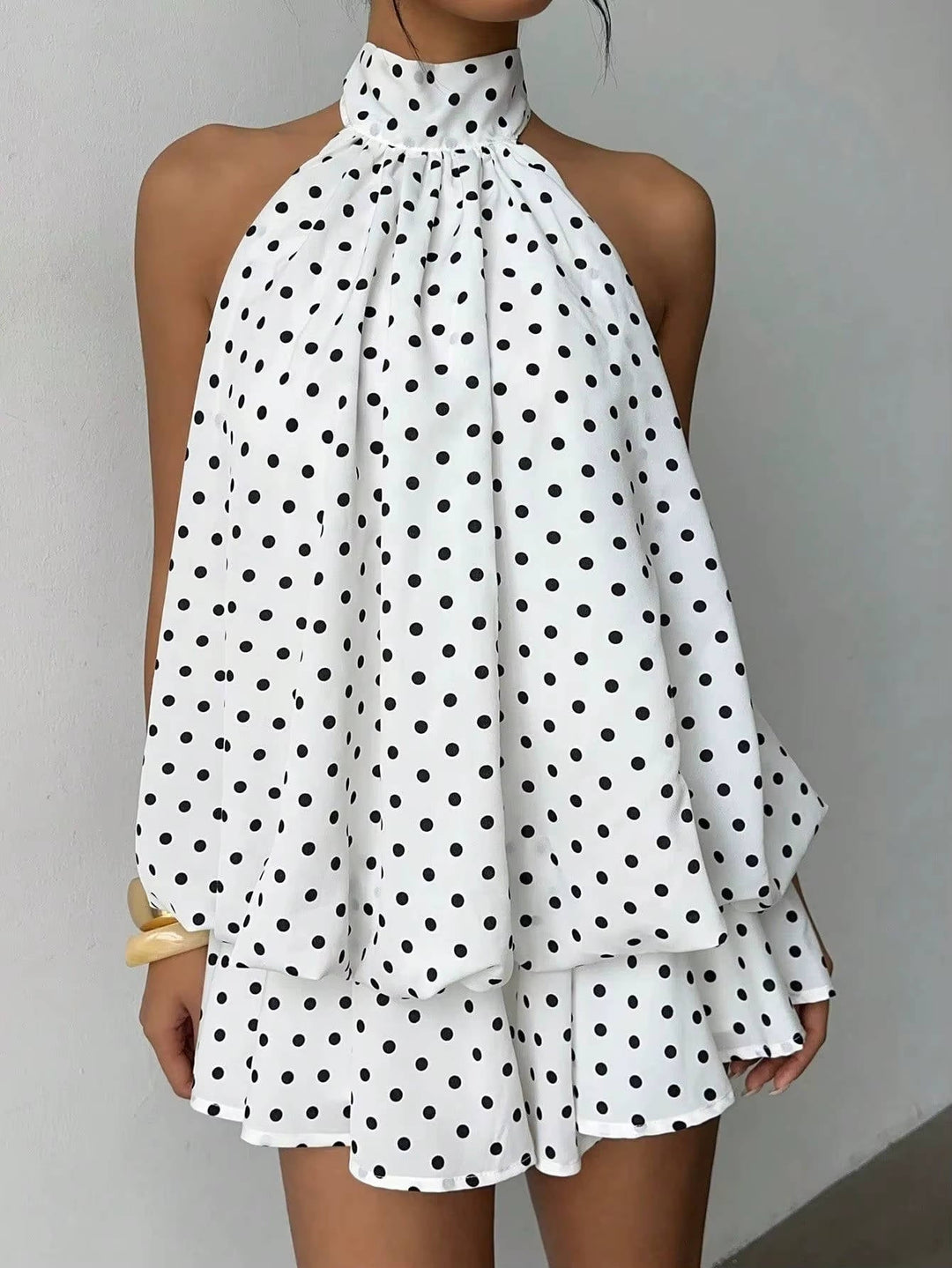 Effortless women's elegant mini dress with a halter neckline, open back, and ruffle details.