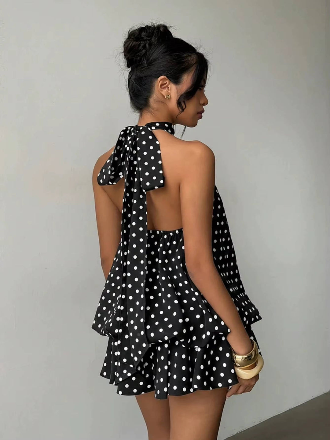 Chic women's party mini dress, open-back halter style, adorned with a pretty ruffle hem.