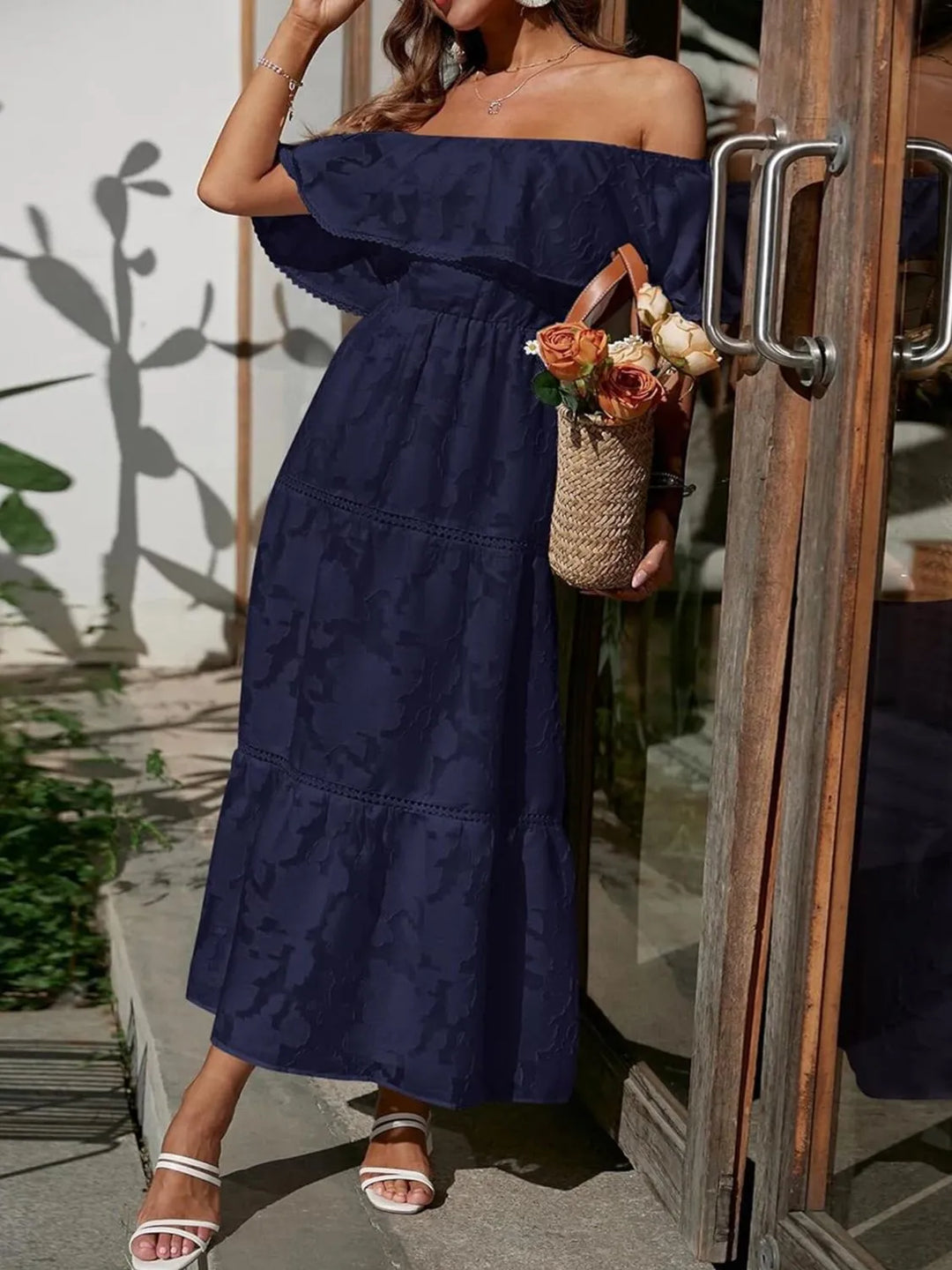 Full-length front view of elegant women's off-shoulder ruffle maxi dress with tiered skirt.