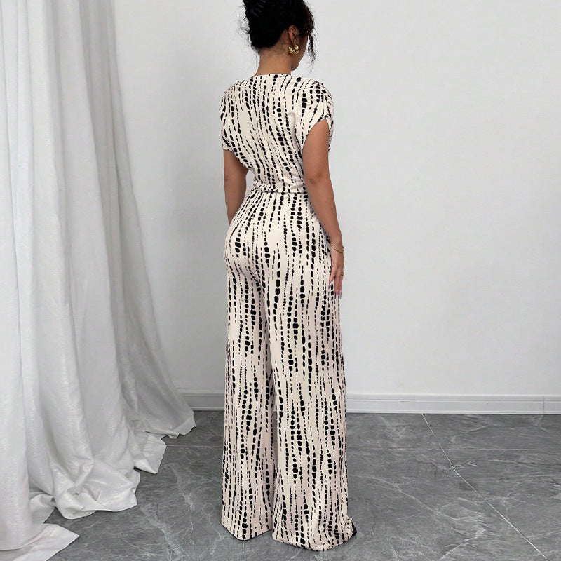 Stylish flowy wide-leg jumpsuit for women, featuring a vibrant print, one-shoulder design, and flattering belt.