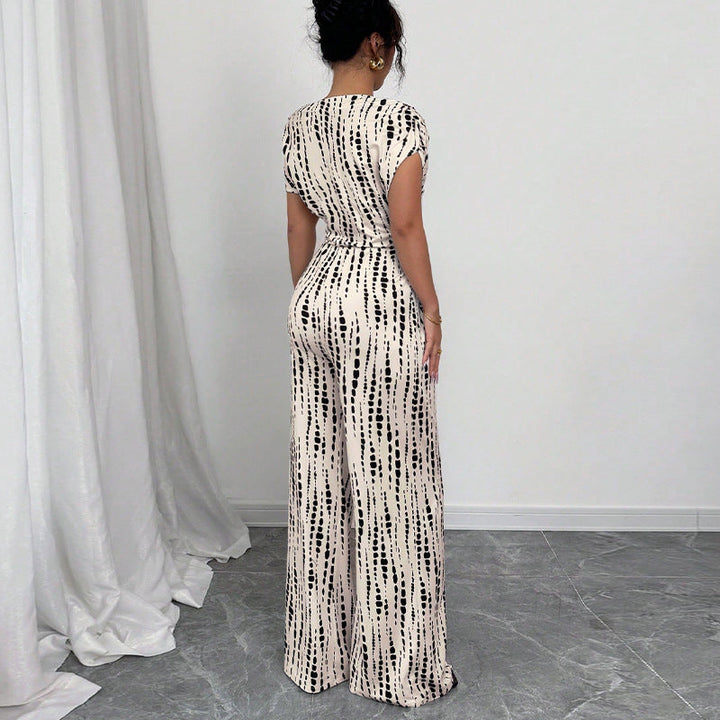 Stylish flowy wide-leg jumpsuit for women, featuring a vibrant print, one-shoulder design, and flattering belt.