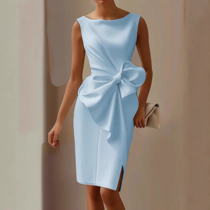 Formal women's occasion wear dress. Sleeveless, elegant with an asymmetric hem & decorative bow for wedding guests.