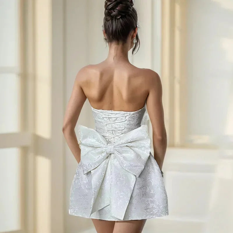 Gorgeous pink cocktail mini dress for women, strapless with an elegant bow back detail, very chic.