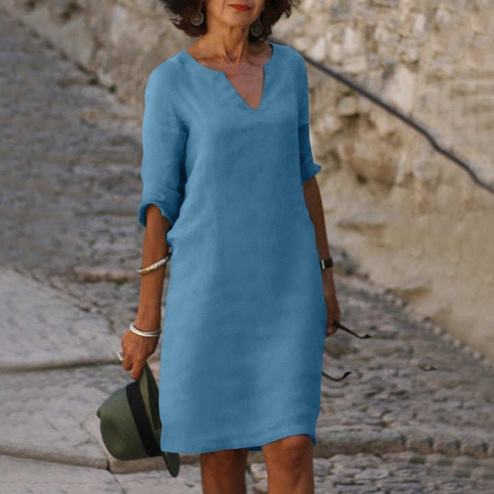 Women's V-neck summer midi dress in an outdoor setting, ideal for casual elegant vacation & spring style.