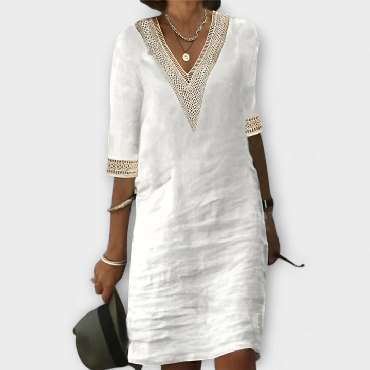 Elegant women's white crochet dress with intricate openwork design, flowy silhouette, perfect for summer resort wear.