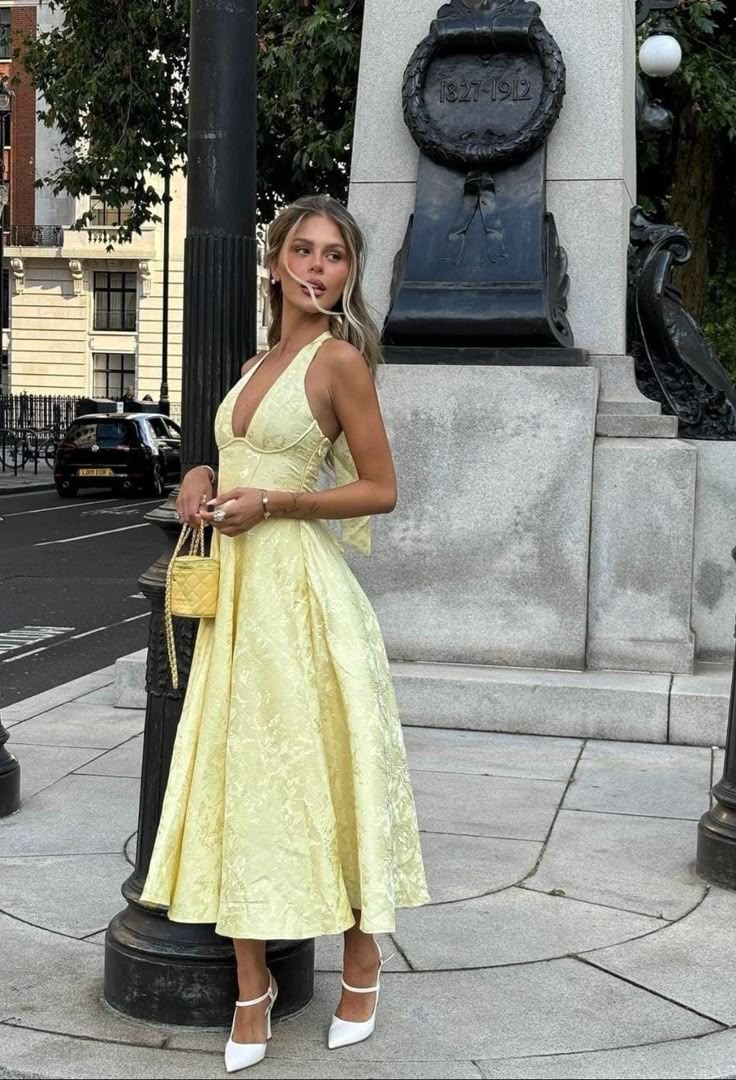 Graceful women's yellow halter midi wedding guest dress featuring a flattering corset bodice. Elegant for events.