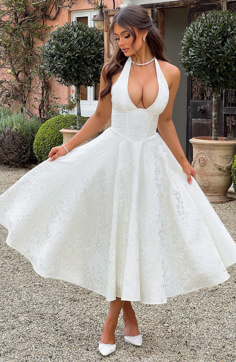 Sophisticated women's yellow corset halter midi dress, an elegant summer wedding guest or formal special occasion outfit.