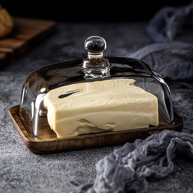 Acacia wood butter dish with a sleek glass lid, ideal for fresh butter or cheese serving; a stylish kitchen decor.