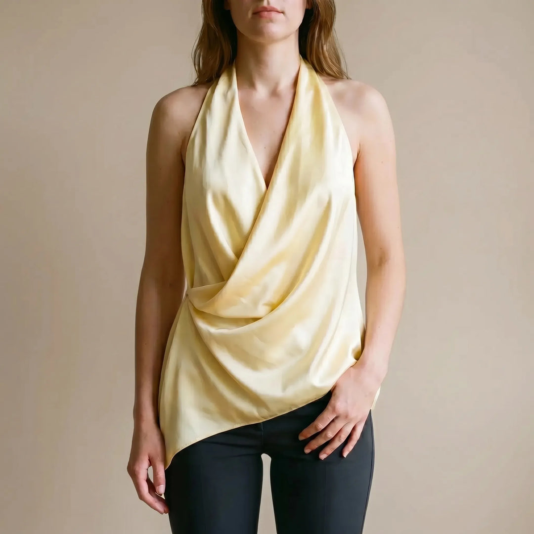 Elegant yellow women's draped halter top with an asymmetrical hem, perfect for summer evenings and casual chic style.