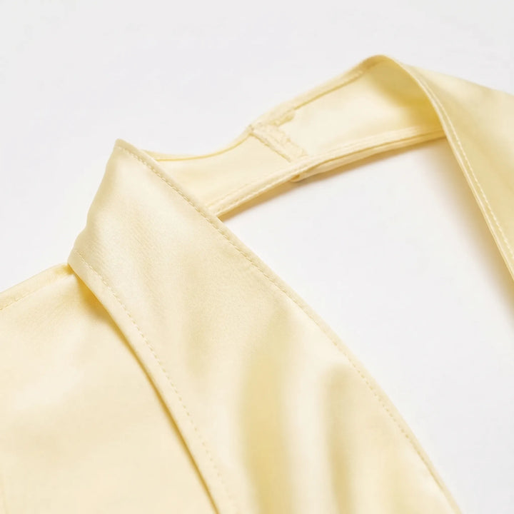 Chic yellow women's halter top, elegantly draped with an asymmetrical hem and stylish open back, ideal for summer fashion.
