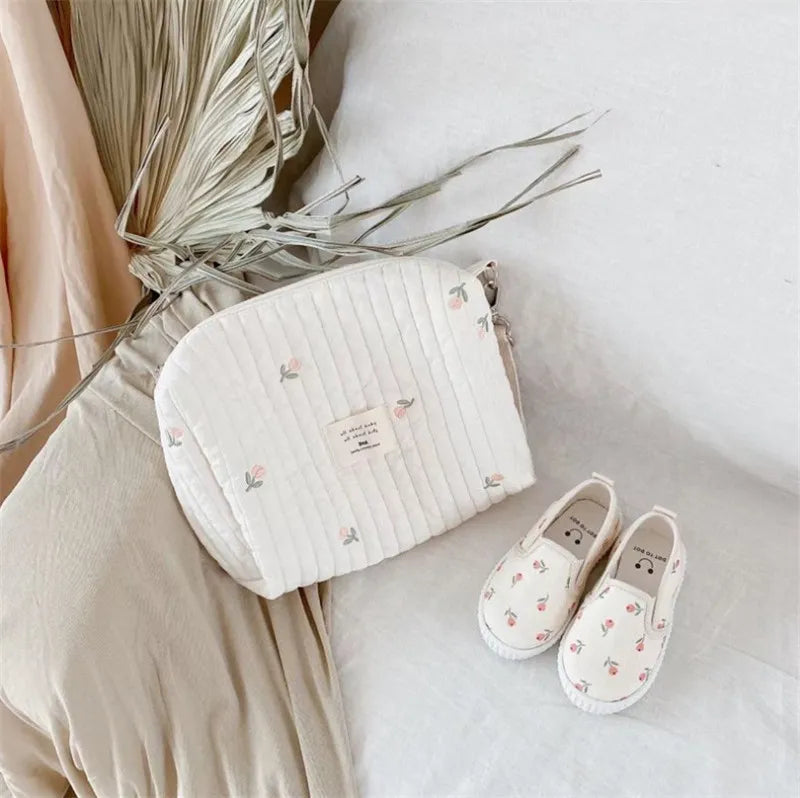 Embroidered baby bag for stroller, functioning as a diaper caddy and organizer for newborn needs