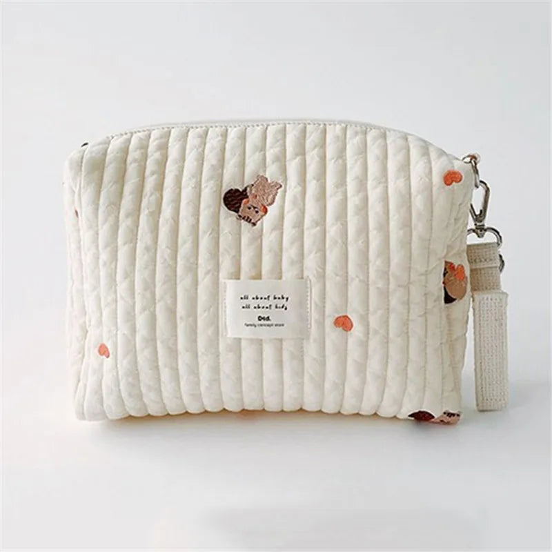 Detailed view of embroidery on a cotton stroller organizer and diaper caddy, soft baby accessory