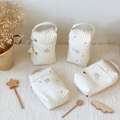 Embroidered cotton travel diaper bag with sturdy strap, designed for stroller use.