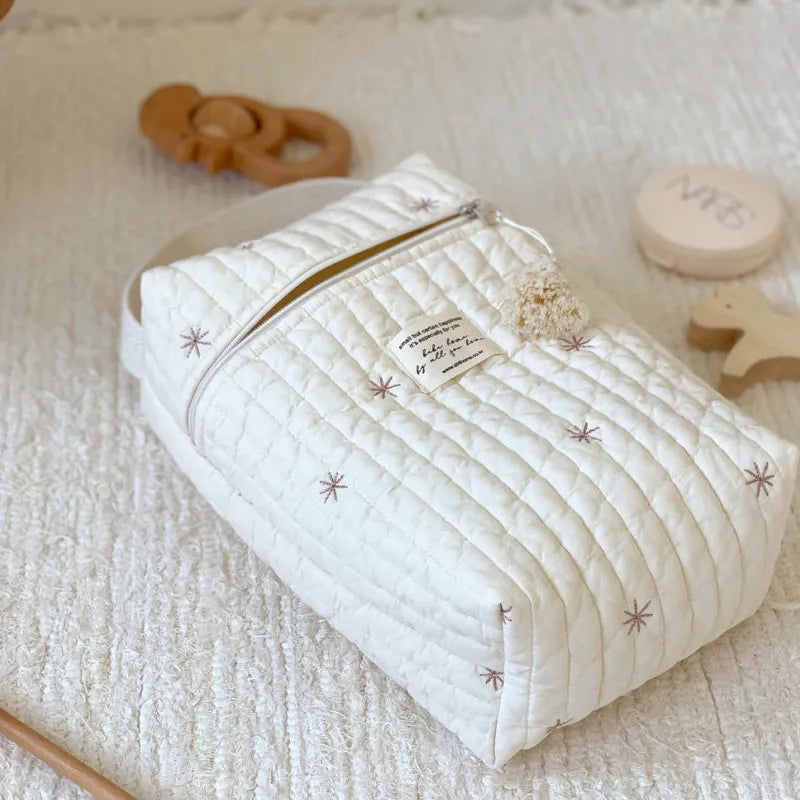 Group of embroidered diaper wet bags in various colors, stylish baby storage solutions.