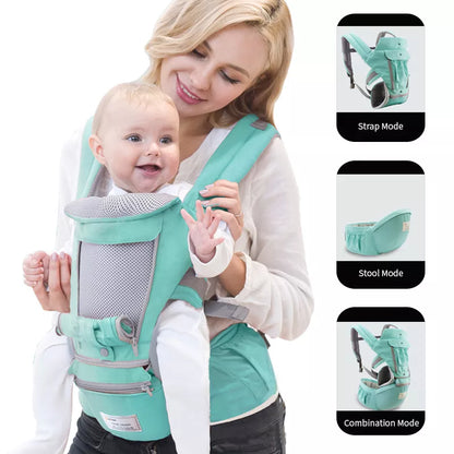 Parent carrying an infant in a black ergonomic hipseat carrier, designed for easy travel