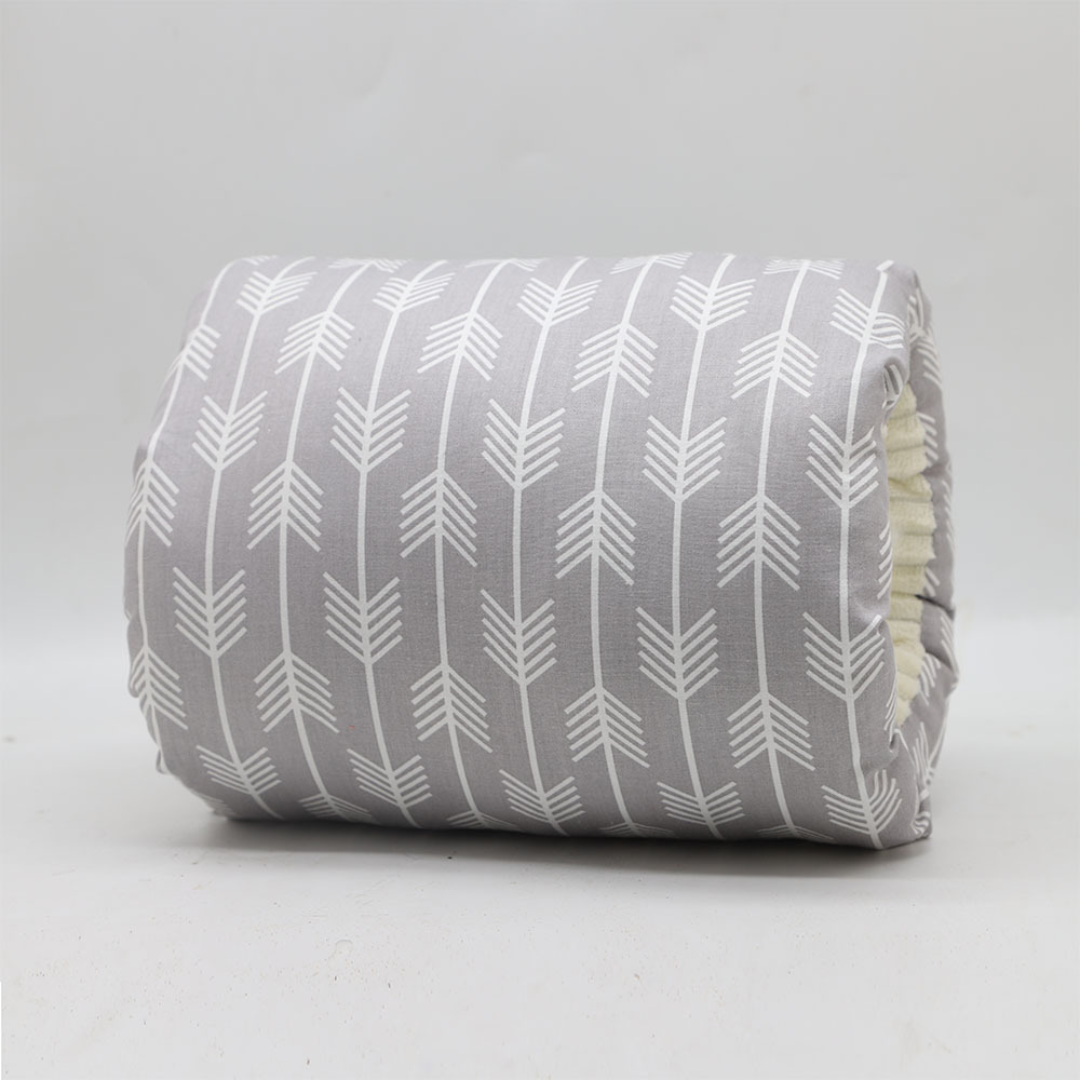 Happy baby resting comfortably on a soft ergonomic nursing pillow during a feeding session