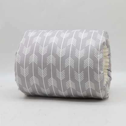 Happy baby resting comfortably on a soft ergonomic nursing pillow during a feeding session