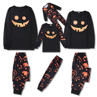 Family in matching Halloween pumpkin print pajamas, smiling on a sofa, perfect for holiday lounging.