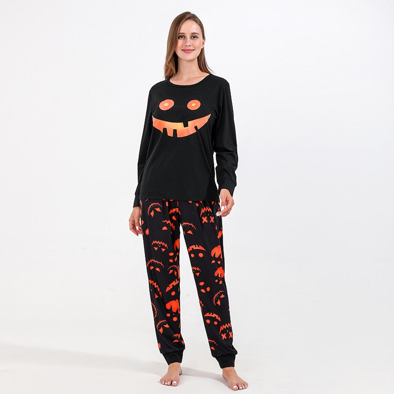 Detail of Halloween themed pajama top with fall leaves and pumpkins design, great for family holiday photos.