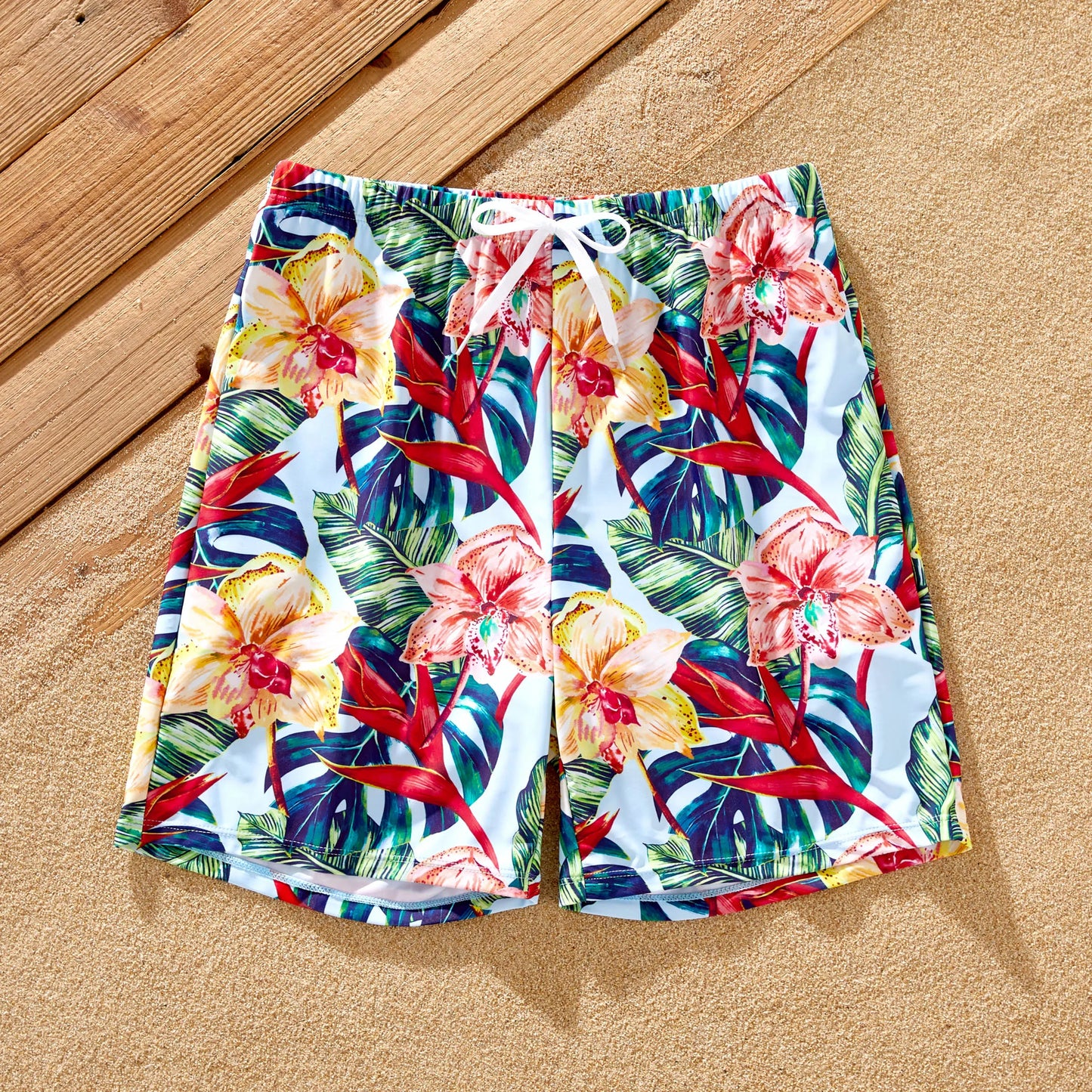 Men's pink floral swim trunks, matching dad's beachwear for vacation attire.
