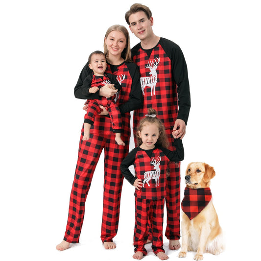 Family in matching plaid reindeer Christmas pajamas, smiling together in a festive setting