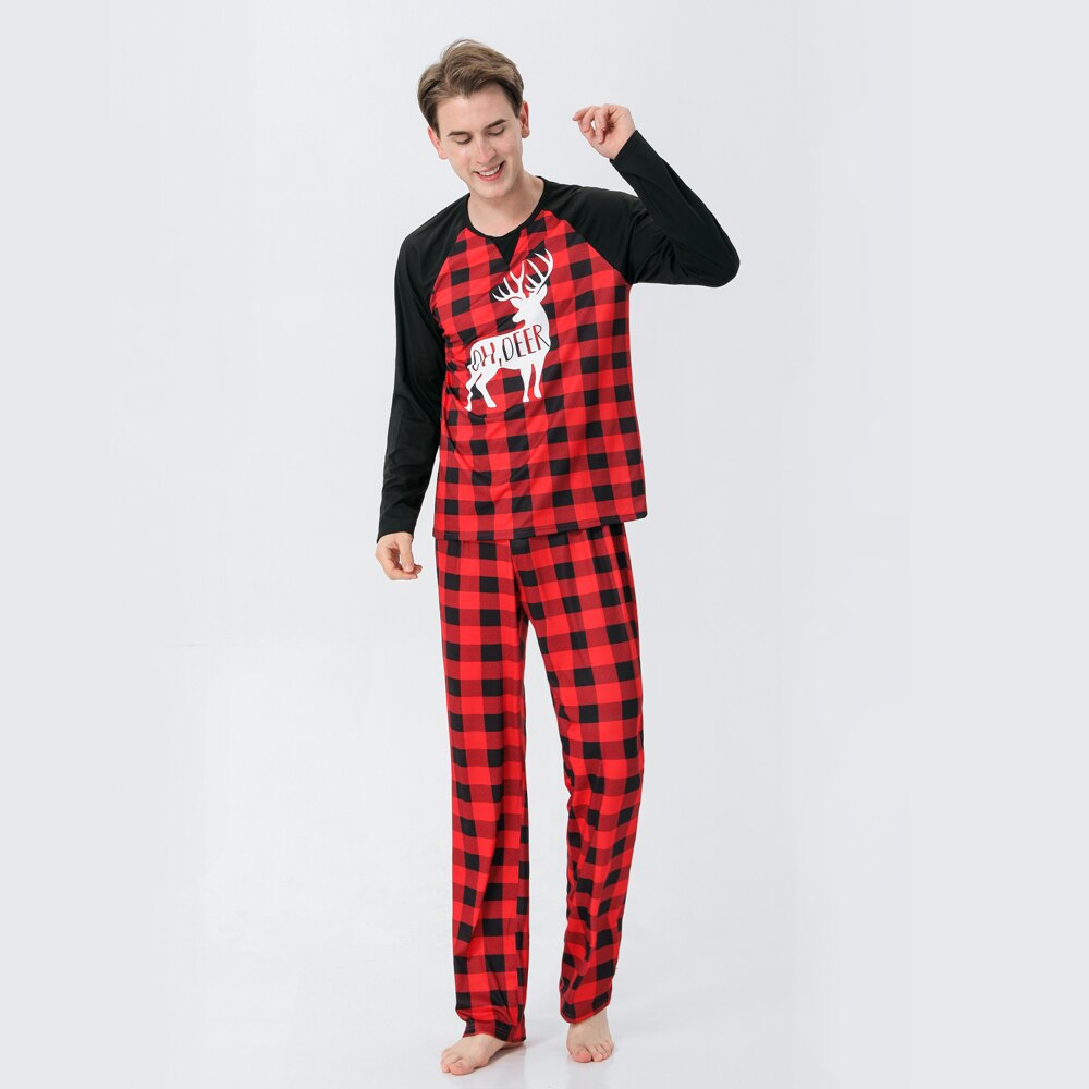 Baby in a festive reindeer plaid sleepsuit, part of a matching family Christmas pajama set